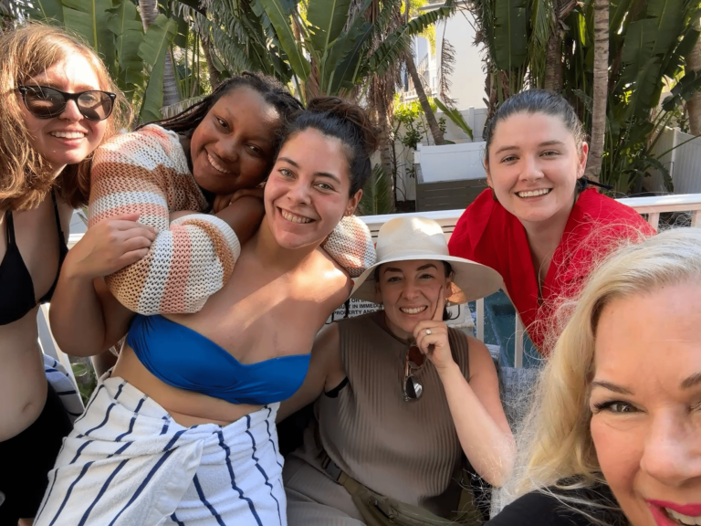 A group of six women posing together outdoors in casual Siesta Key beach attire before their Tarot Readings 